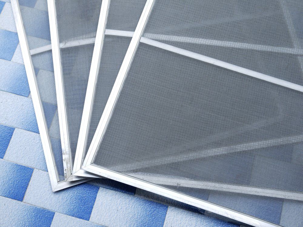 Four Screens Are Stacked On Top Of Each Other On A Checkered Floor — Nambucca Glass in Nambucca Heads, NSW