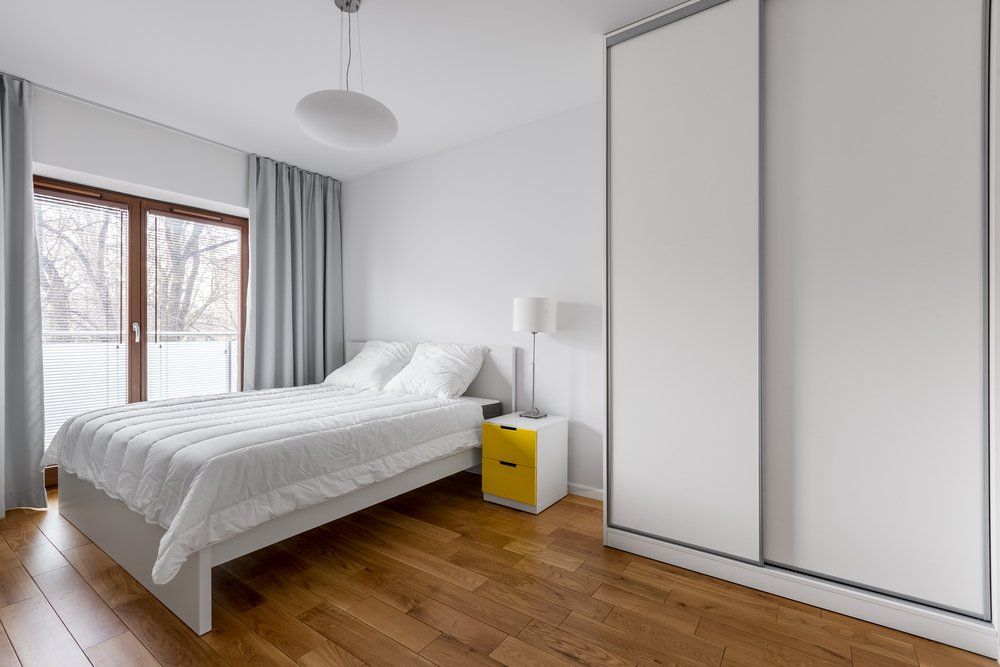 A Bedroom With A Bed , Nightstand , And Sliding Wardrobe — Nambucca Glass in Nambucca Heads, NSW