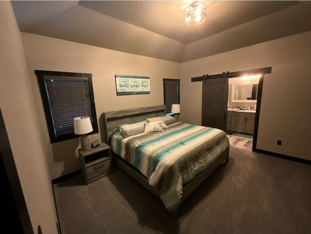 Bedroom with a bed, nightstands, and a sliding barn door leading to the bathroom.