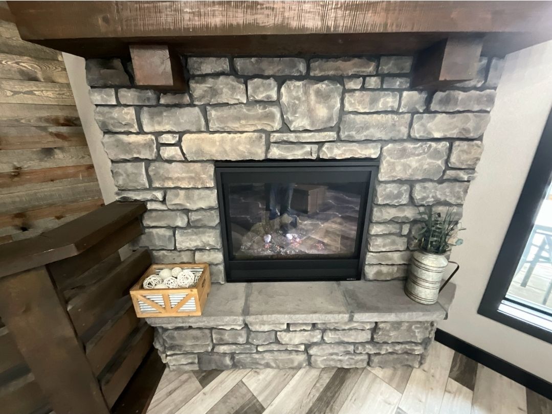 Stone fireplace with a wooden mantle and a decorative basket.