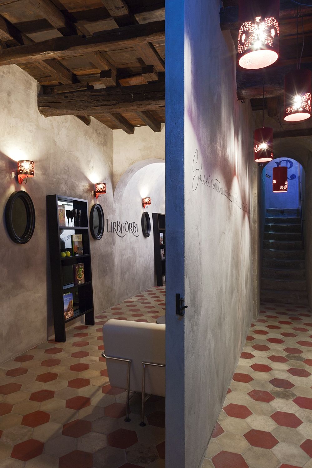 A hallway with a staircase and a bookshelf in the background