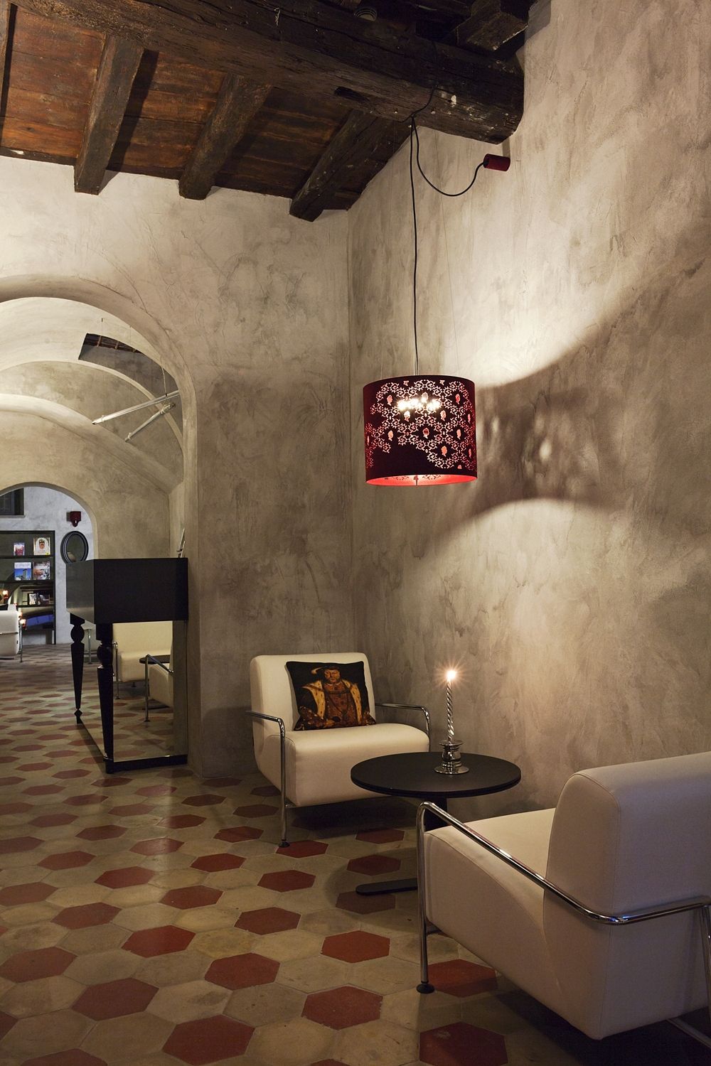 A room with two chairs and a table with a lamp hanging from the ceiling