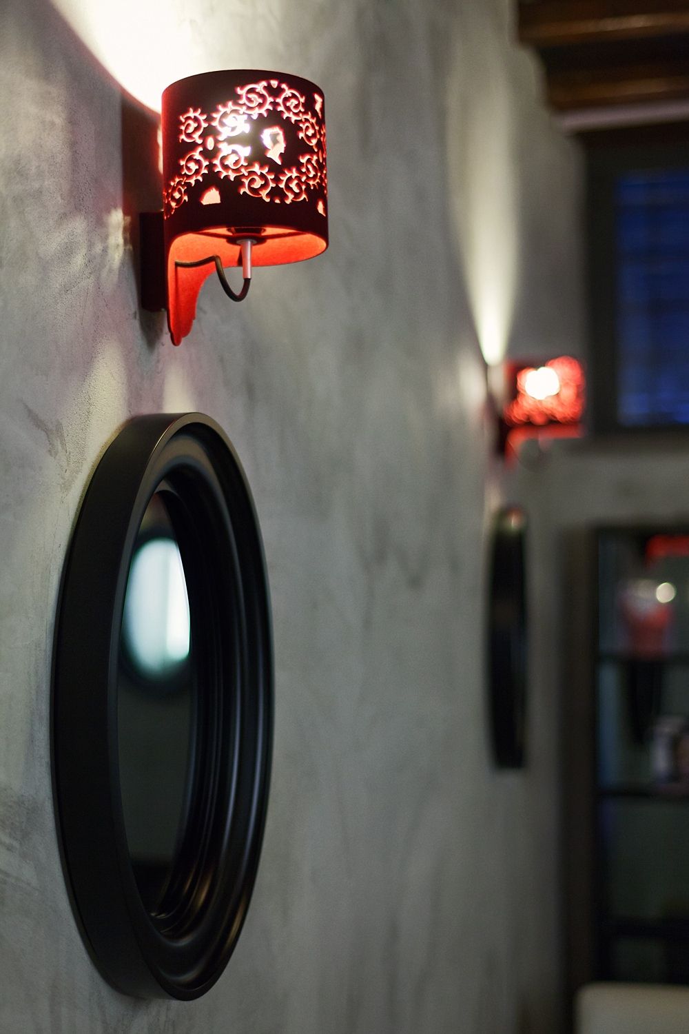 A wall with a mirror and a lamp on it