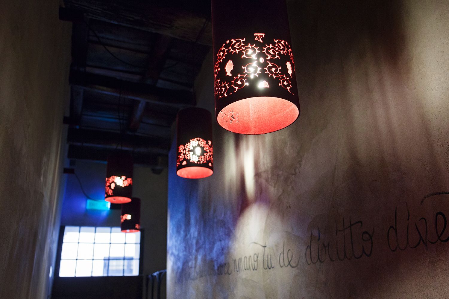 A row of lamps hanging from the ceiling in a dark room