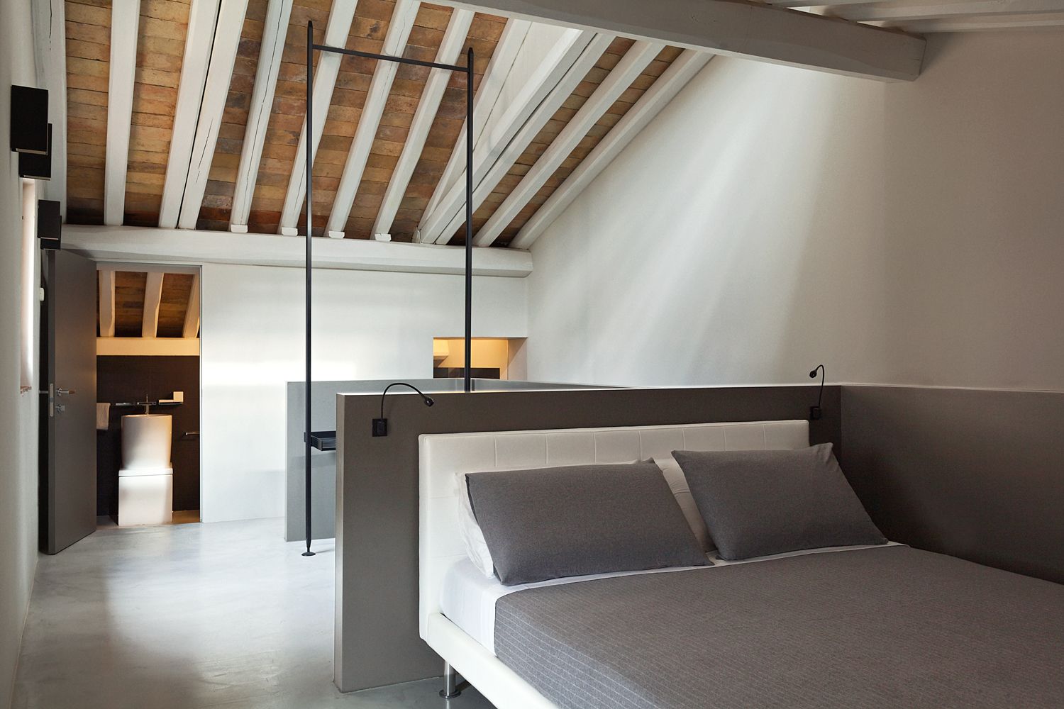 A bedroom with a bed and a wooden ceiling