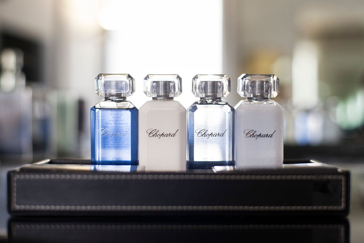 Quattro bottiglie di profumo Chopard sono su un vassoio