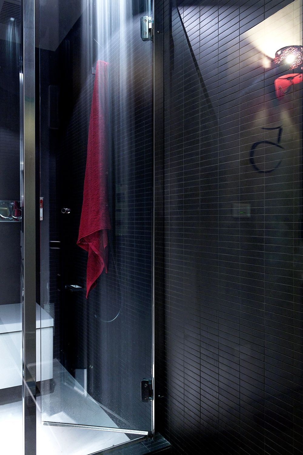 Un bagno con un asciugamano rosso appeso al muro