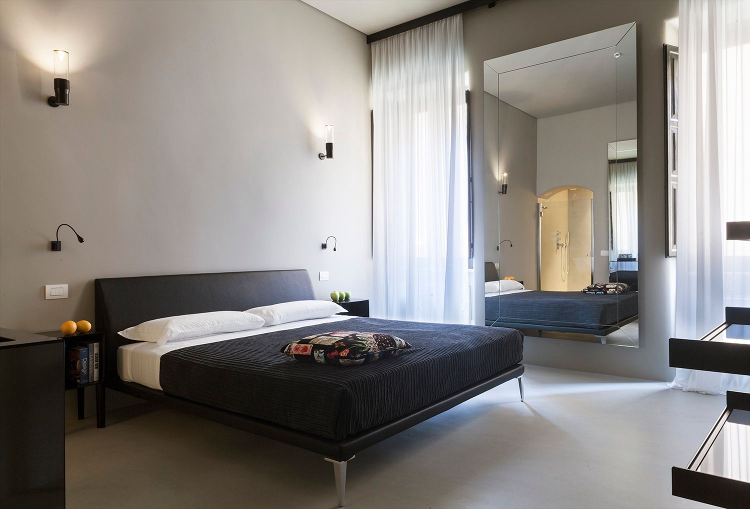 Una camera da letto con un grande specchio e un letto grande