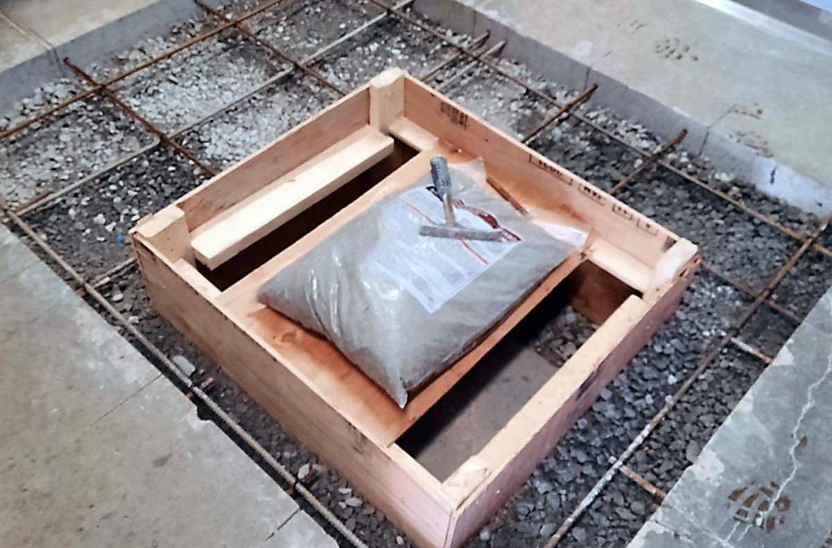 Un sac de ciment est posé dans une caisse en bois