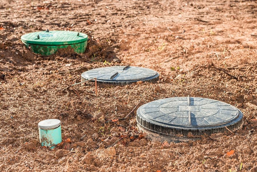 A group of septic tanks sitting on top of a dirt field.
