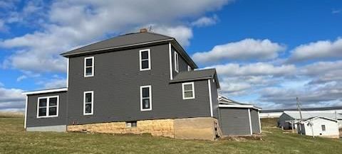 A large house is sitting in the middle of a grassy field.