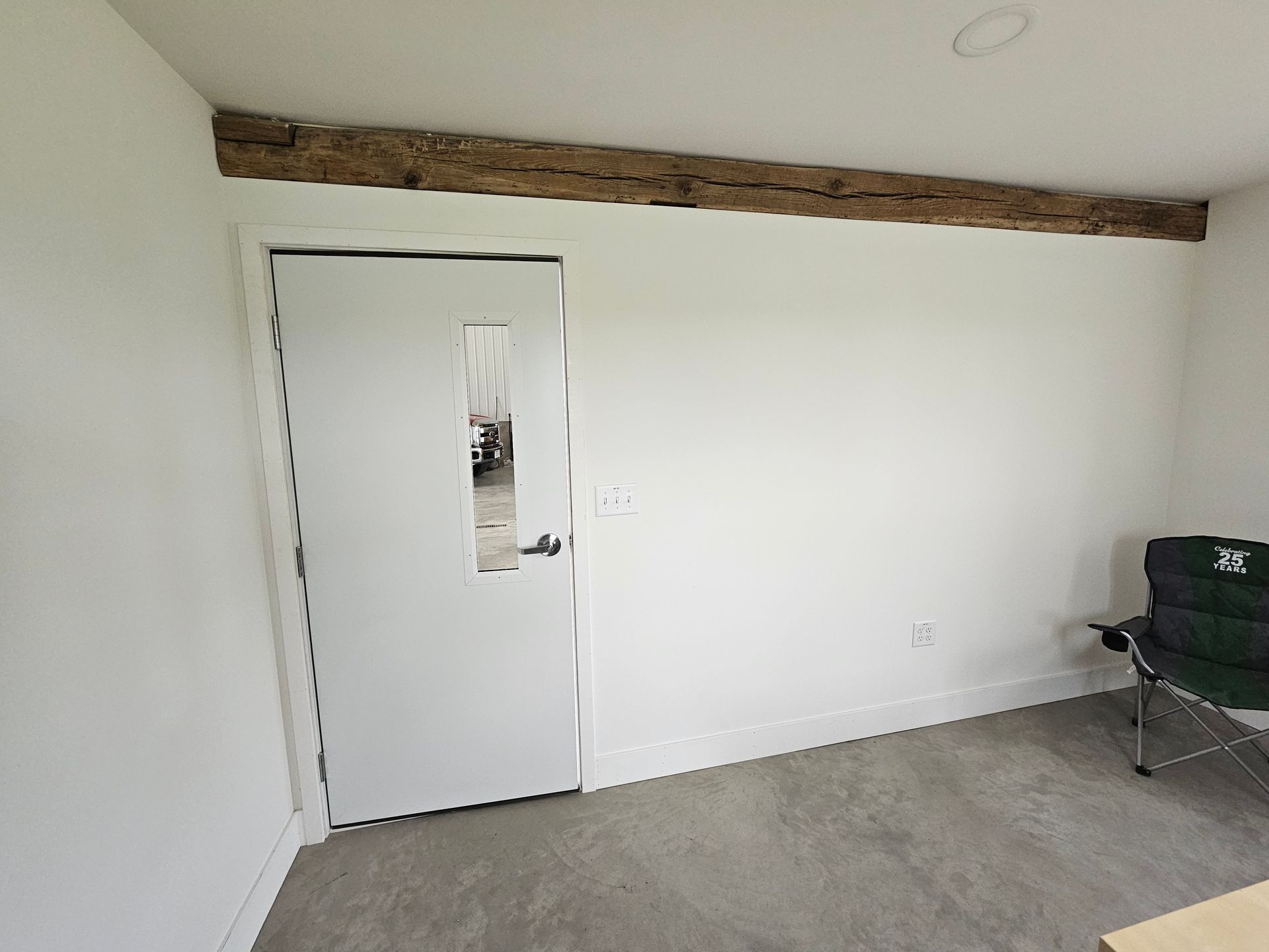 A room with a door and a chair in it.