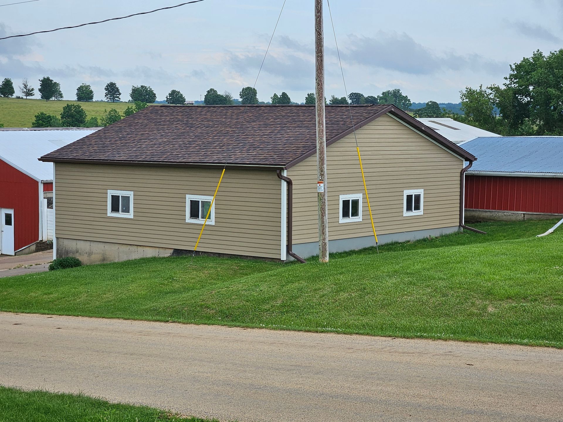 A small house with a red barn in the background