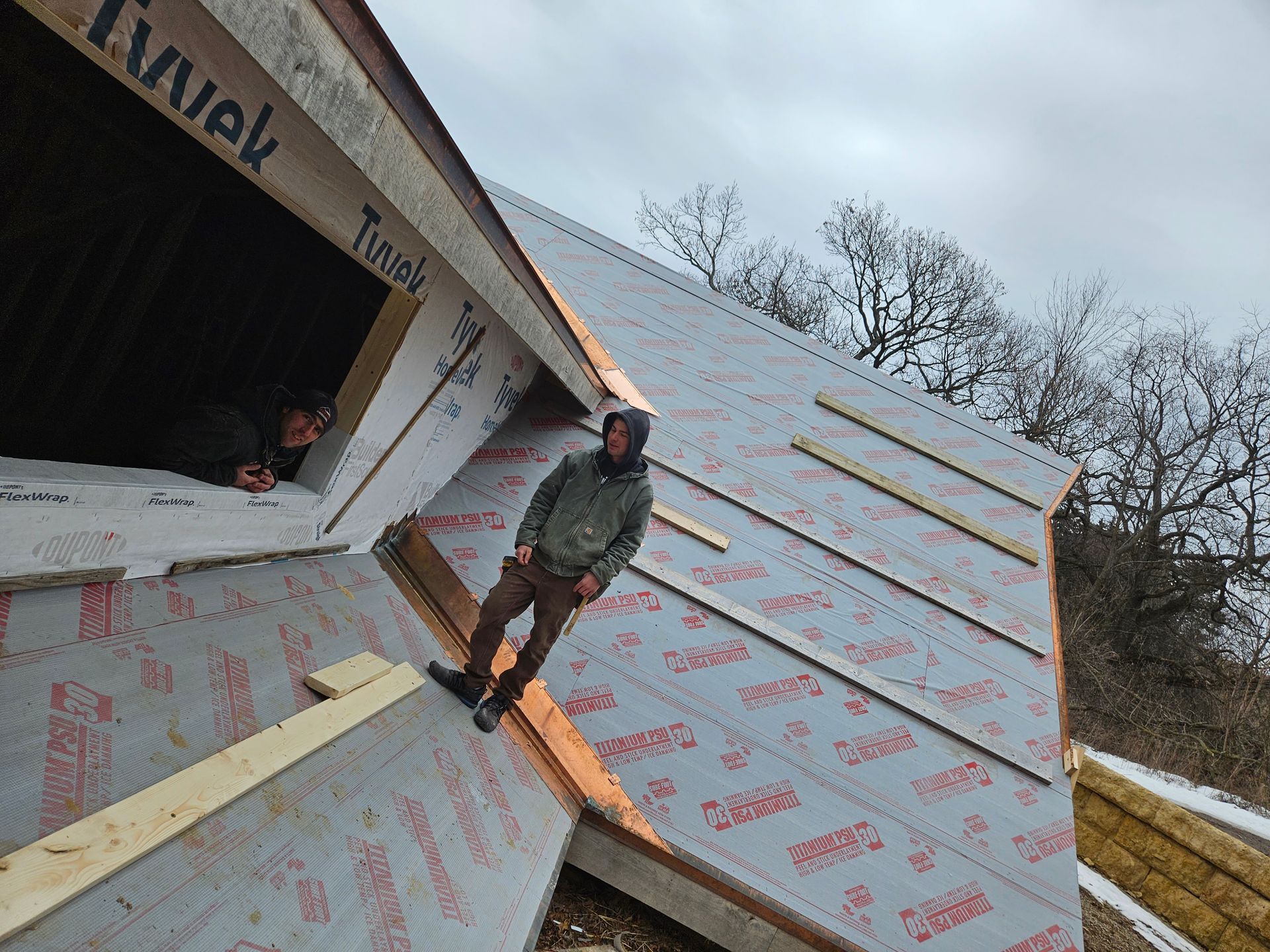 A man is standing on the roof of a building under construction.