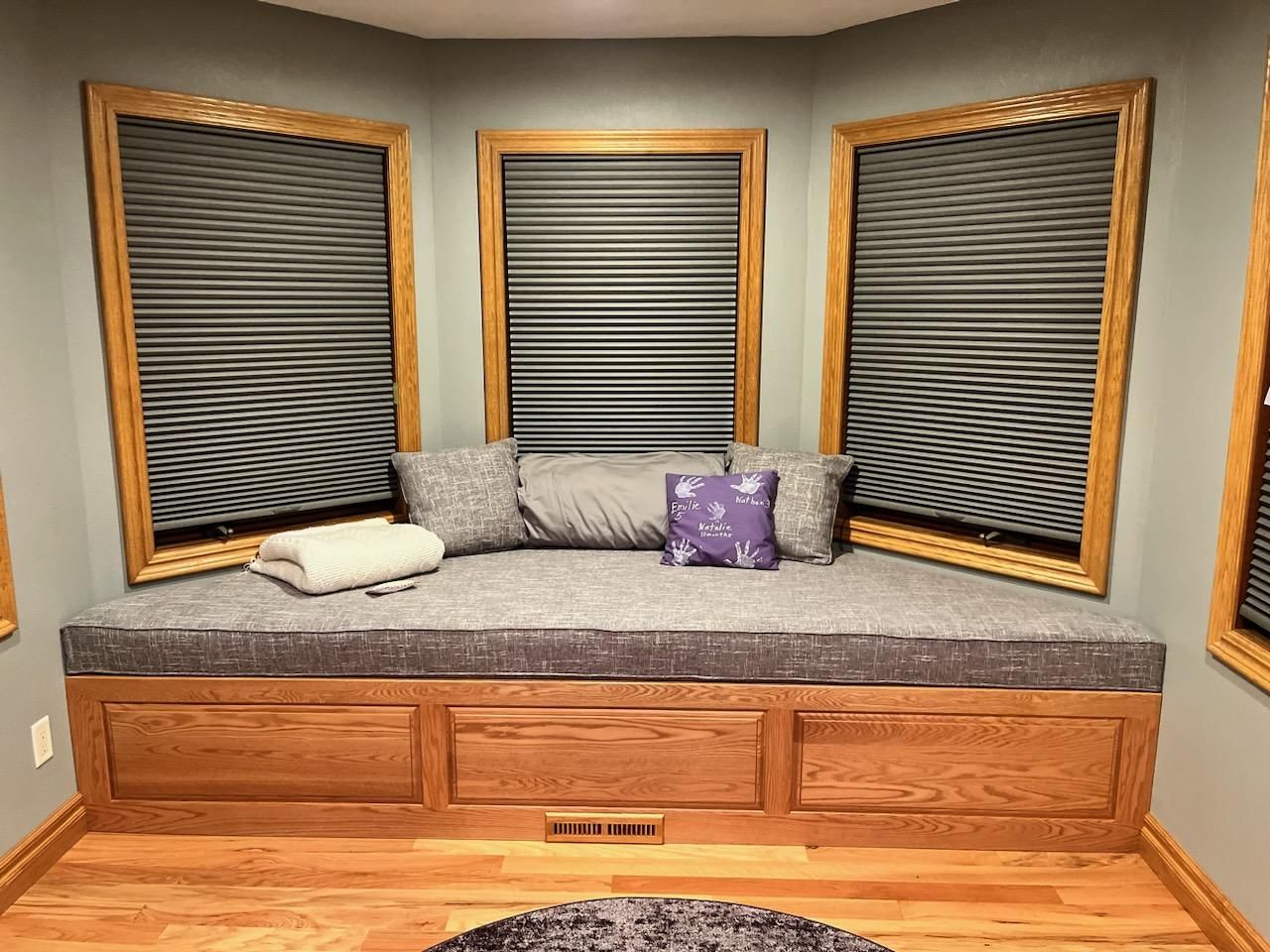 There is a window seat in the corner of the room.