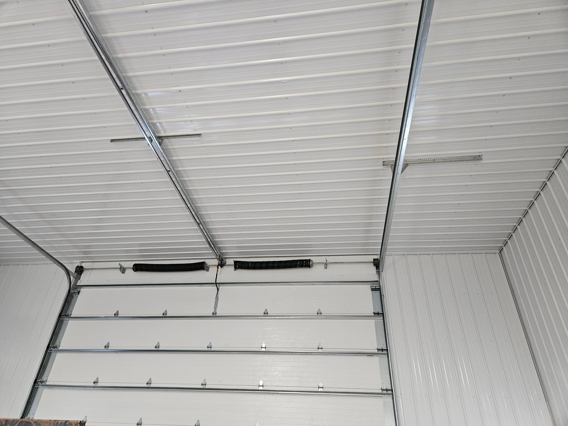 The inside of a garage with a garage door open