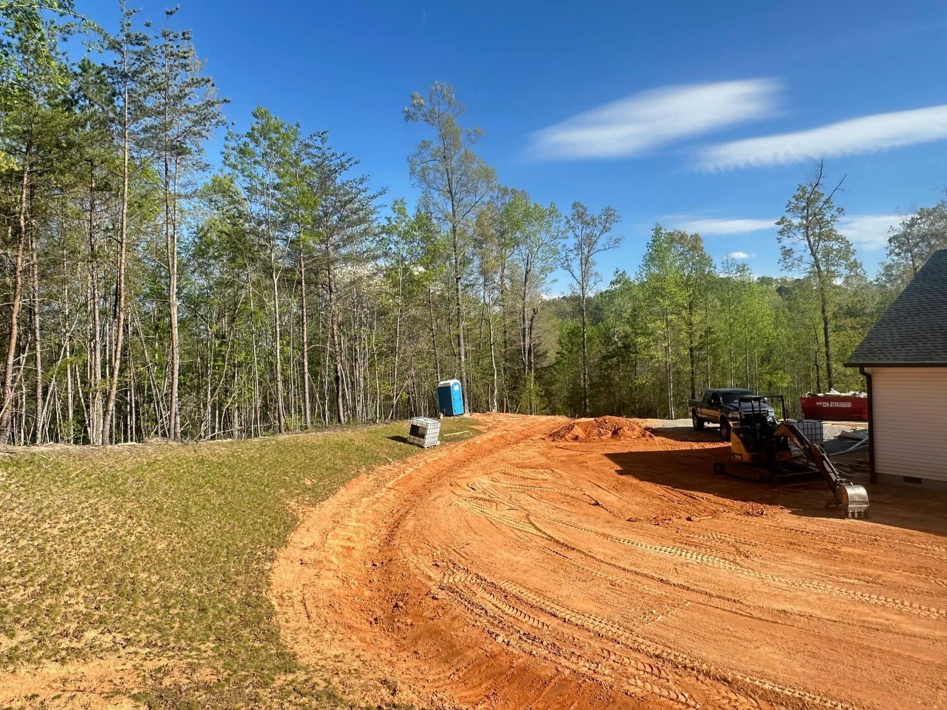 A dirt road leading to a house in the woods.
