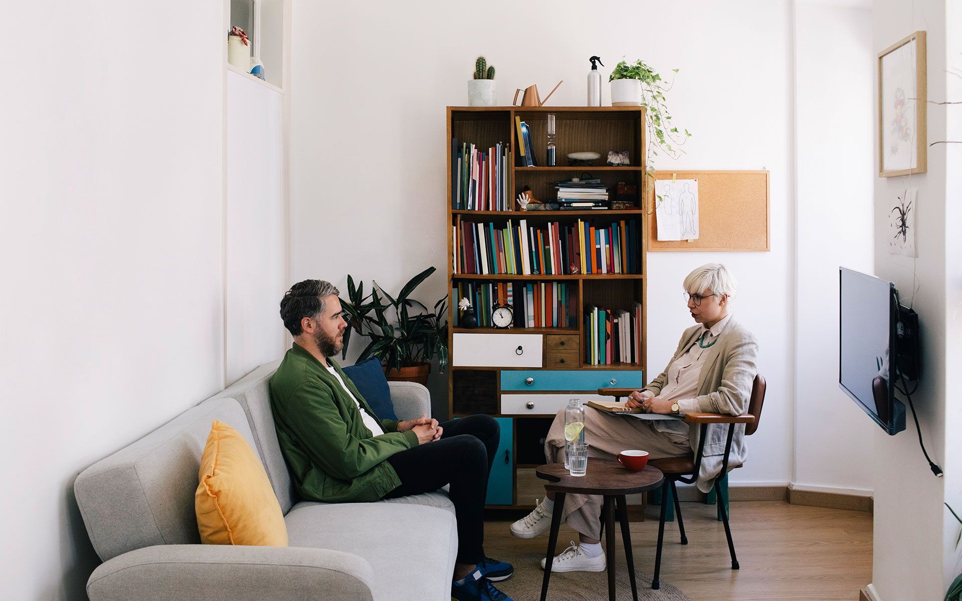 A man and a woman are sitting on a couch in a living room.