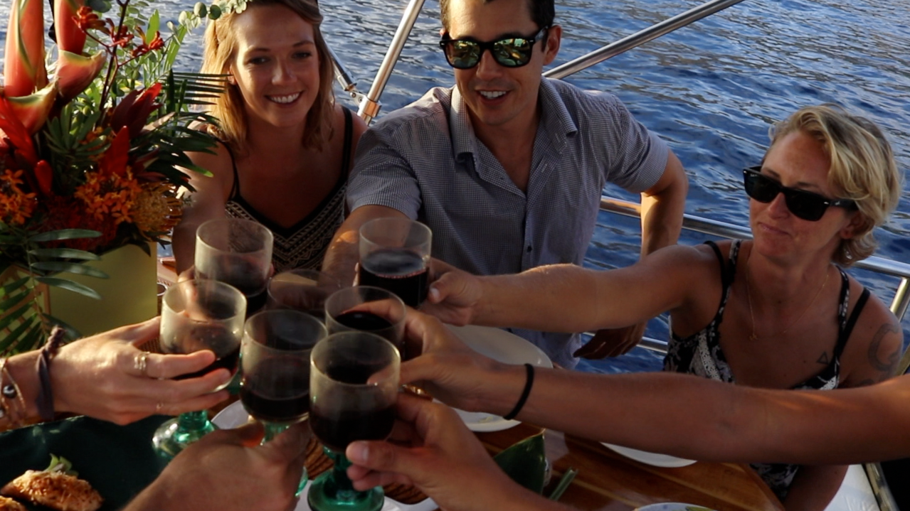 Two women are hugging each other on a boat in the ocean. Two women are hugging each other on a boat in the ocean.