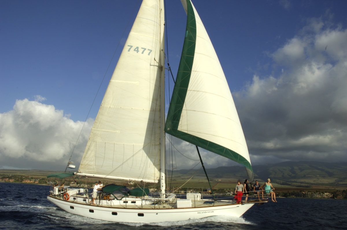 A group of people are sitting on the deck of a boat looking at the ocean. A group of people are sitting on the deck of a boat looking at the ocean.