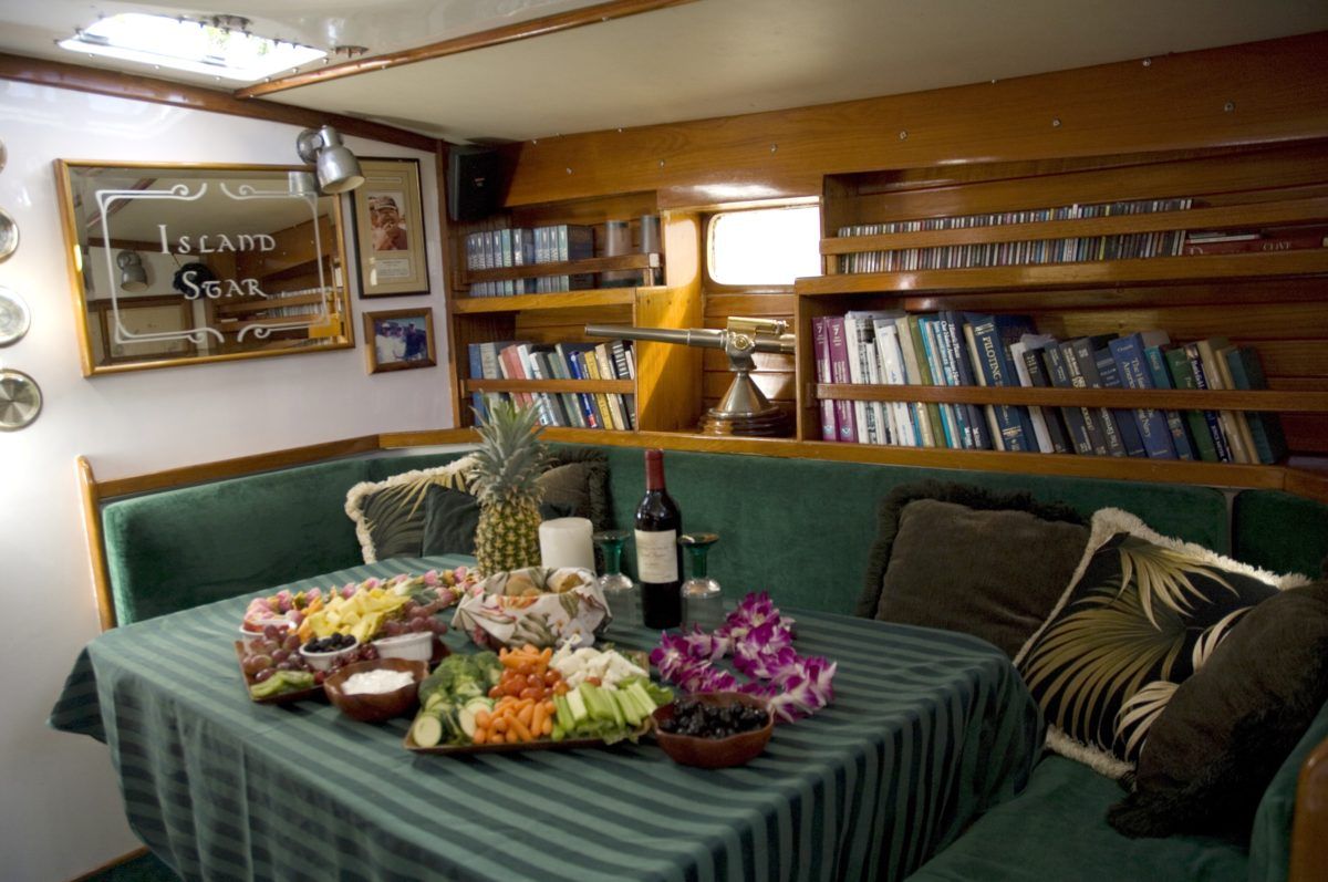 A dining room with a table and a bottle of wine