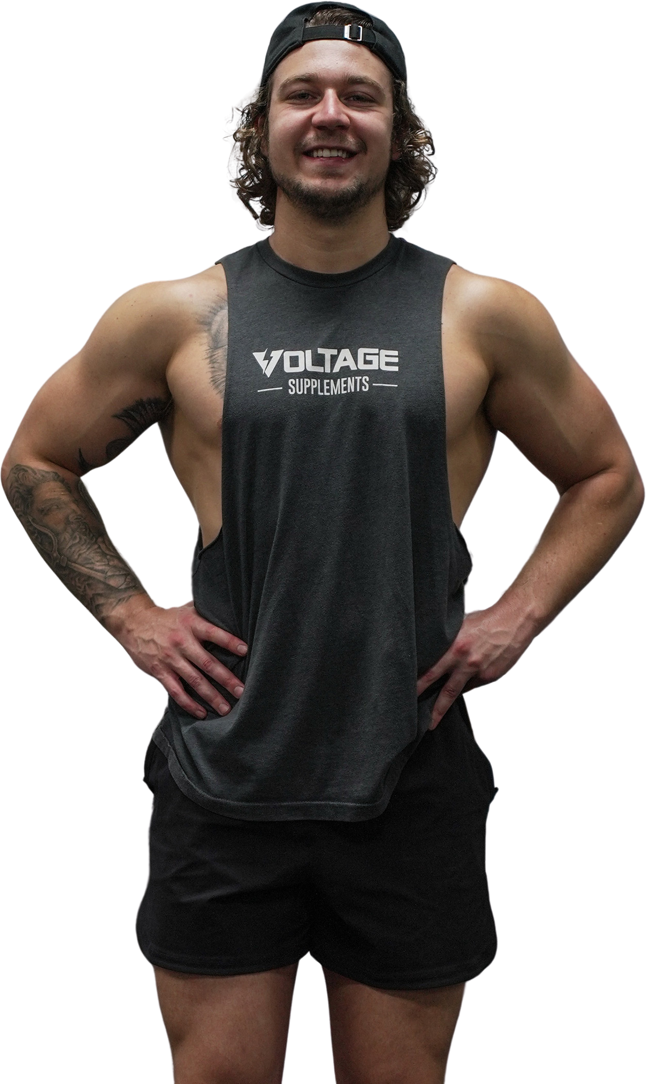 A shirtless man wearing a tank top and shorts is standing with his hands on his hips.