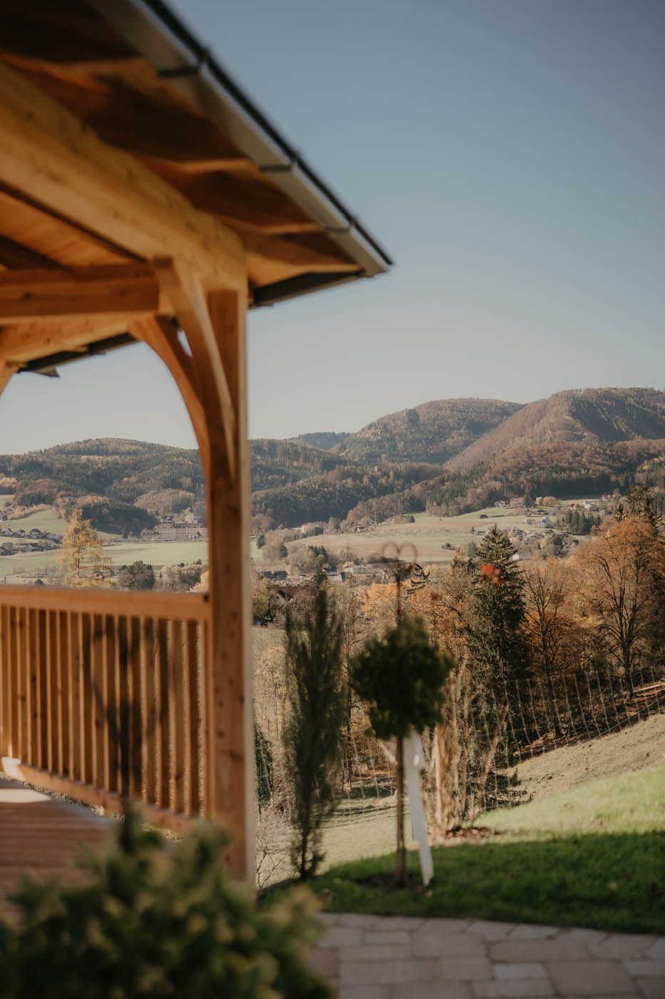 Ein hölzerner Pavillon mit Blick auf sanfte Hügel und Bäume an einem sonnigen Tag.