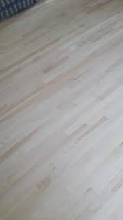 Parquet clair avec un motif de lames discret et des ombres douces.