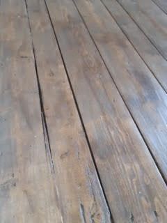 Plancher en bois vieilli, au grain gris-brun et aux joints étroits