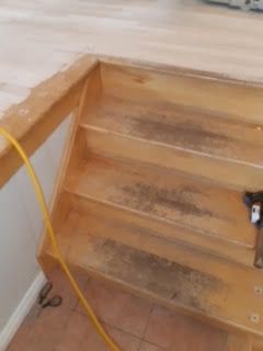 Escalier en bois en cours de réparation, avec des marches usées et un câble jaune sur le côté.