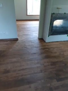Pièce vide avec parquet, une porte et une cheminée ou un radiateur mural
