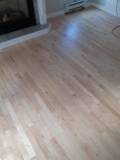 Parquet clair dans un salon près d'une cheminée.