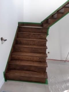 Escalier en bois avec garniture verte dans une pièce intérieure inachevée