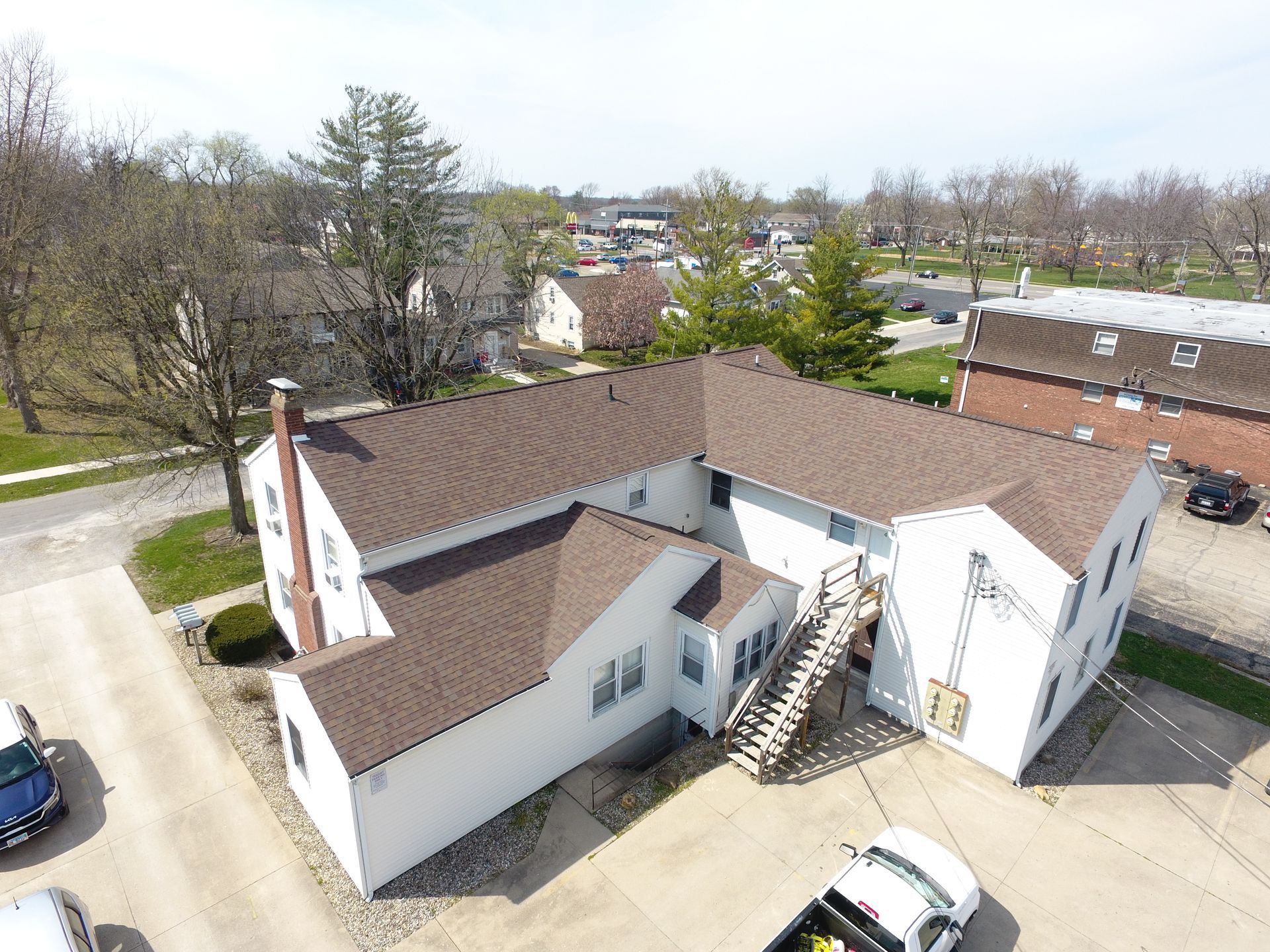 An aerial view of a large white building with a brown roof.