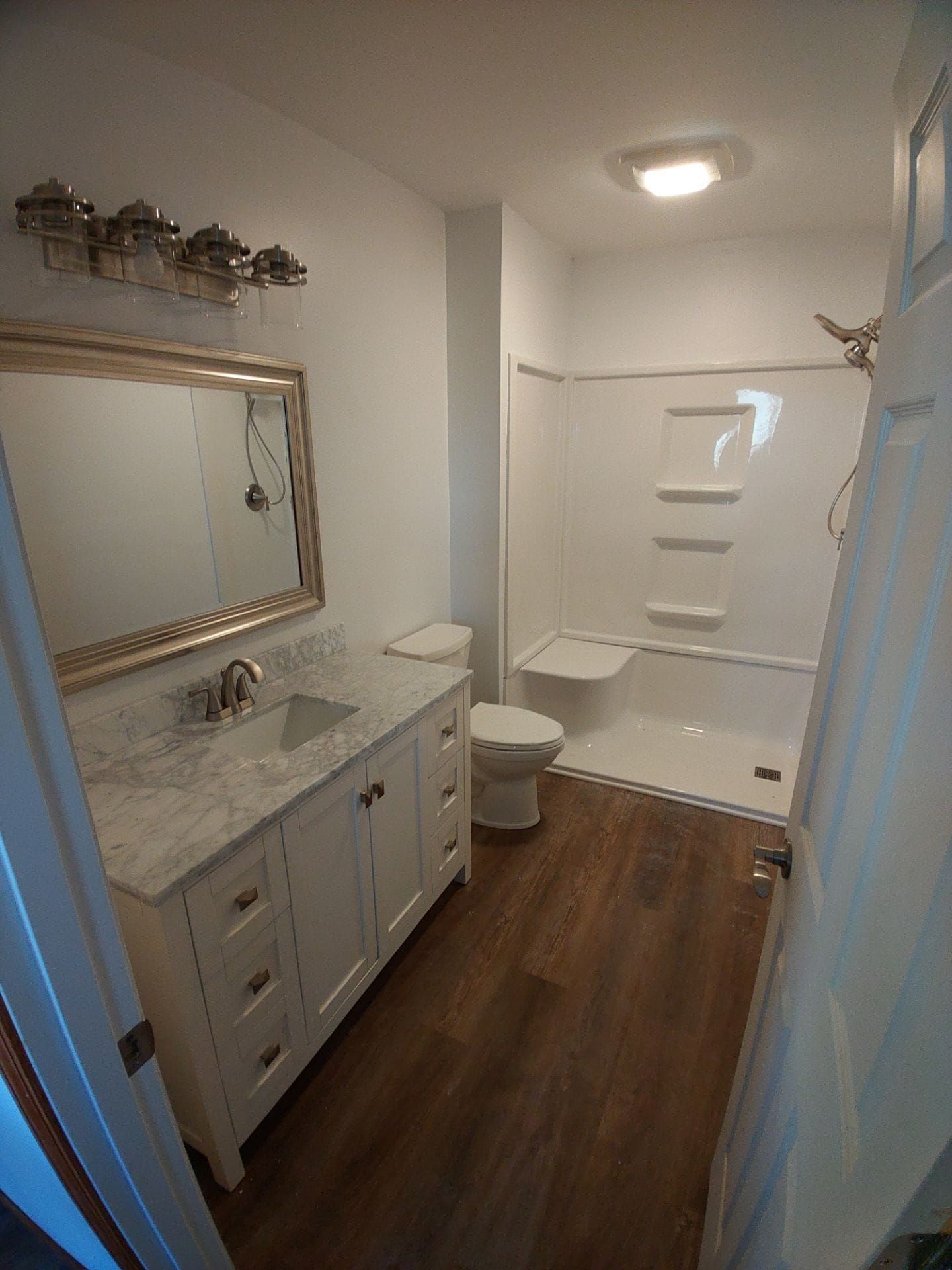 A bathroom with a sink , toilet , bathtub and mirror.