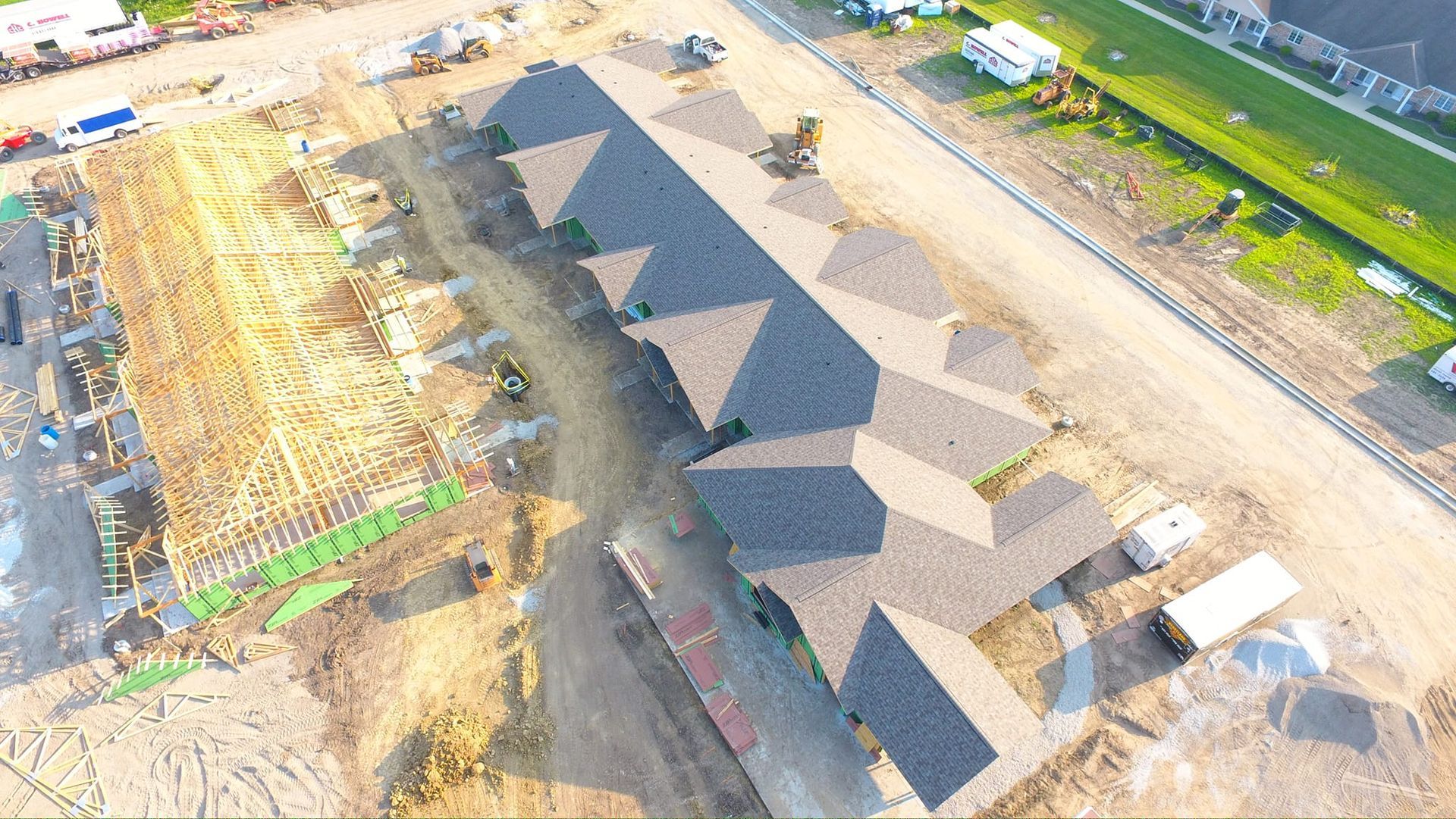 An aerial view of a building under construction in a residential area.