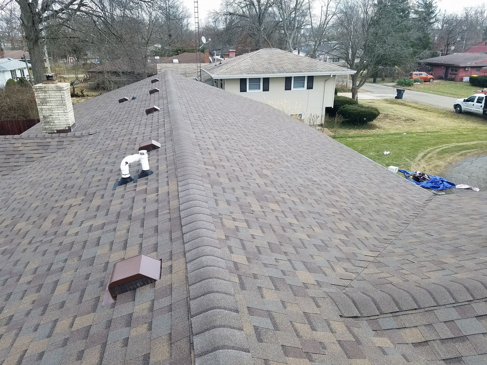 An aerial view of a roof of a house with a truck parked in front of it.
