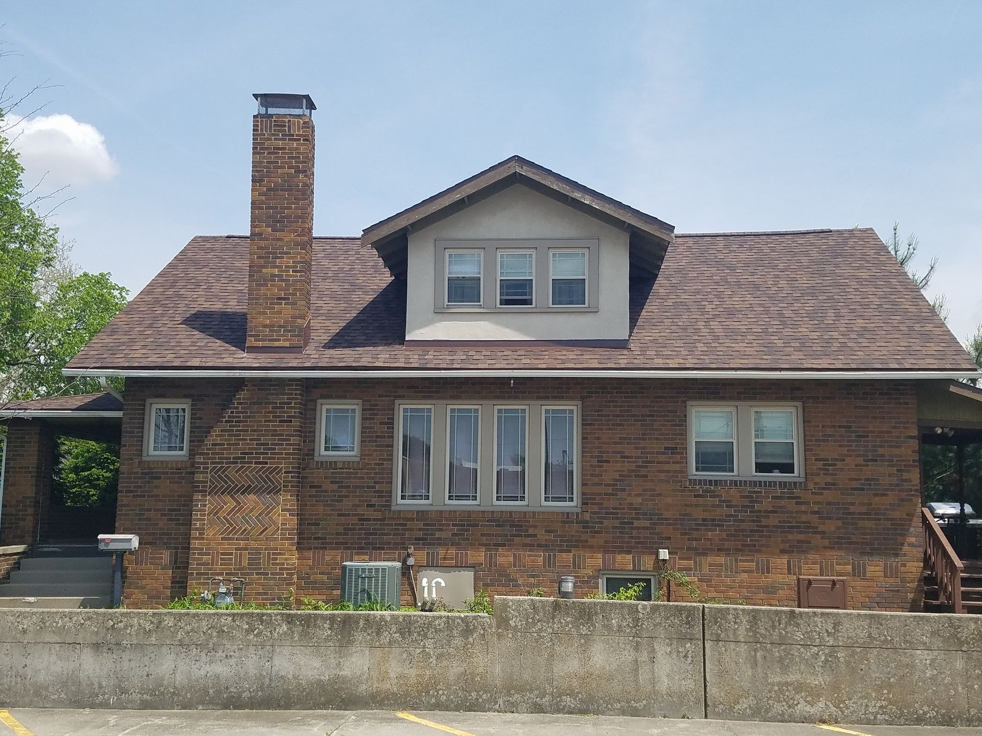 A brick house with a brown roof and a chimney