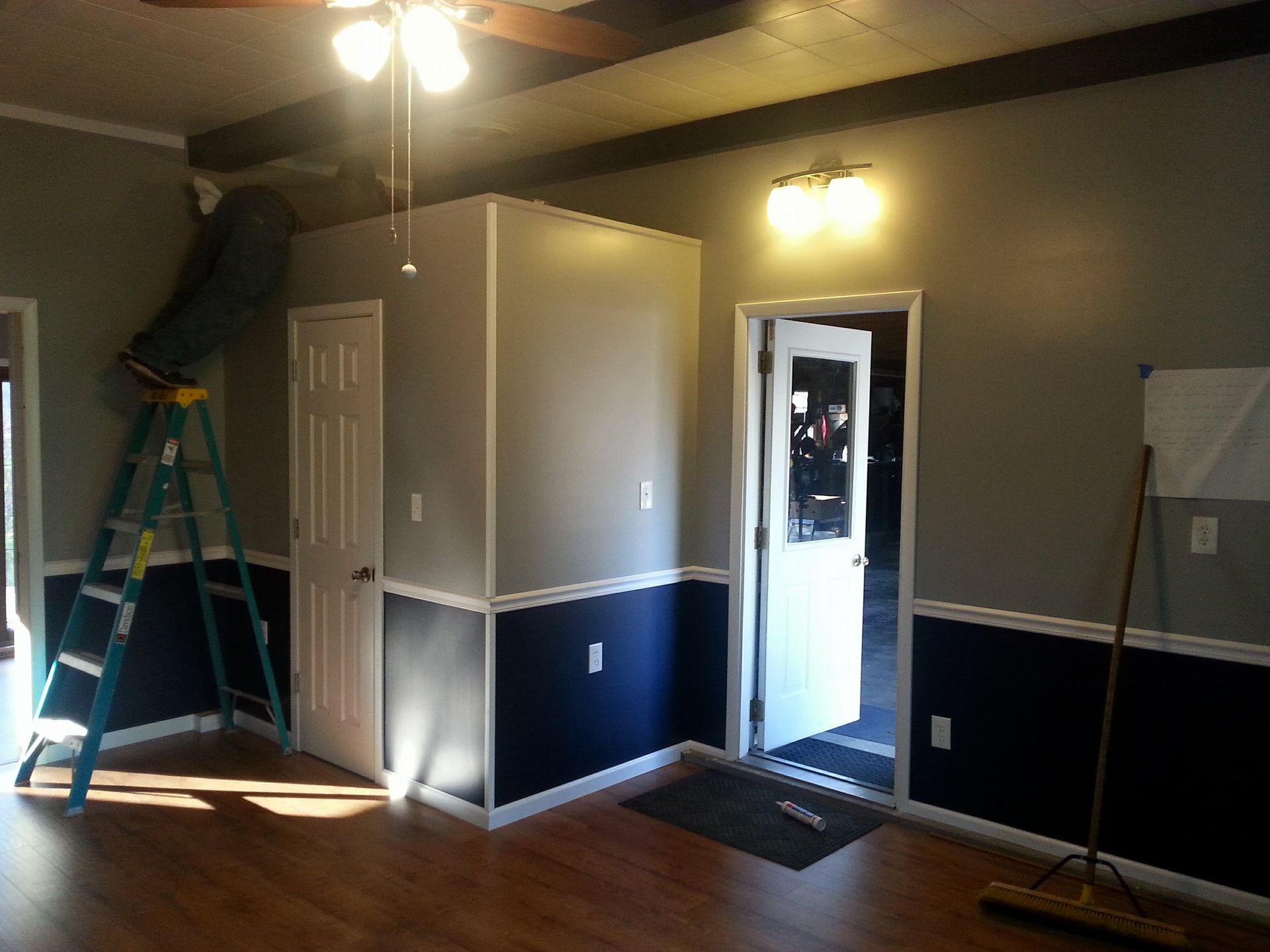 A room with a ladder and a broom in it
