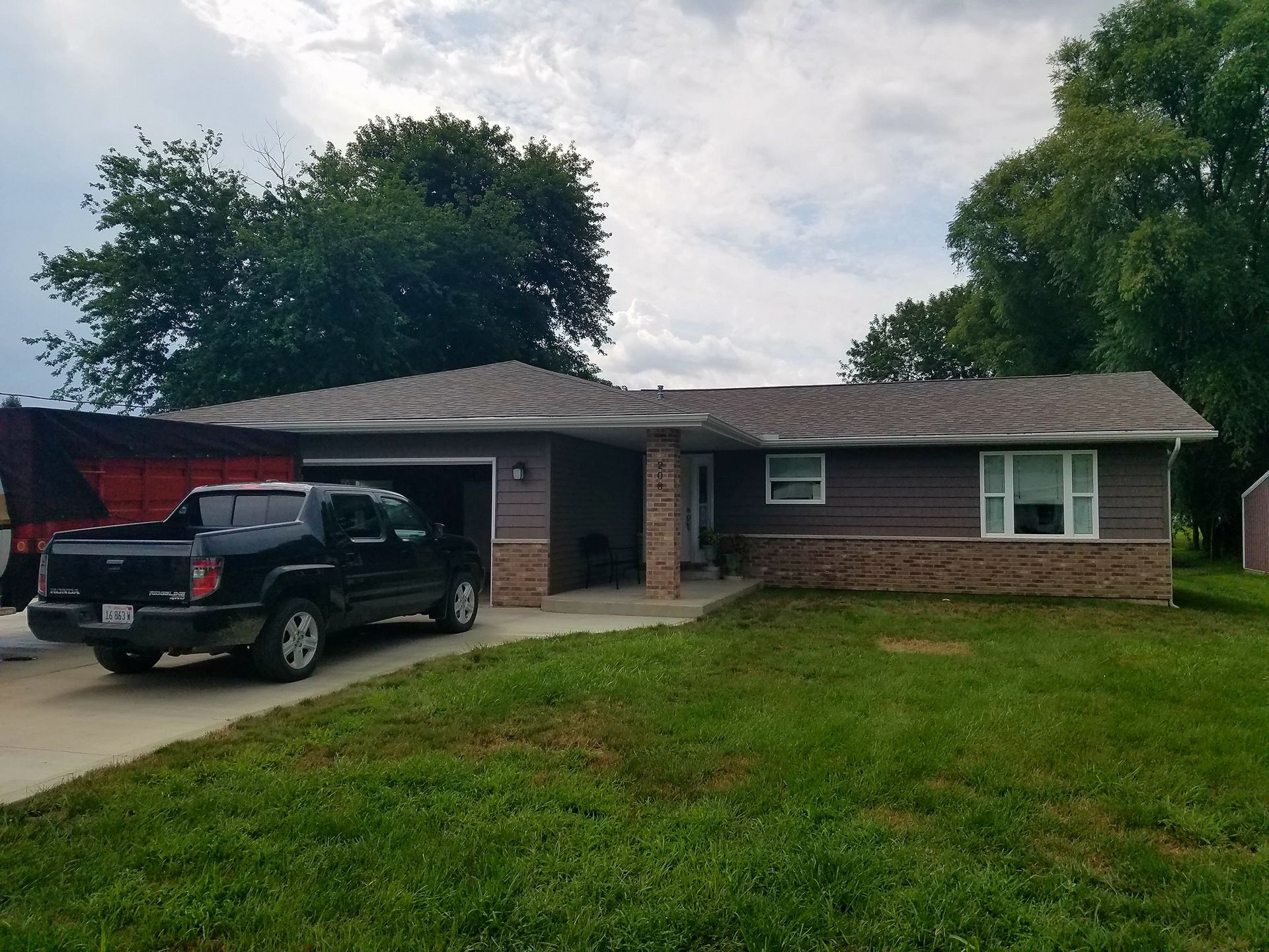 A black truck is parked in front of a house.