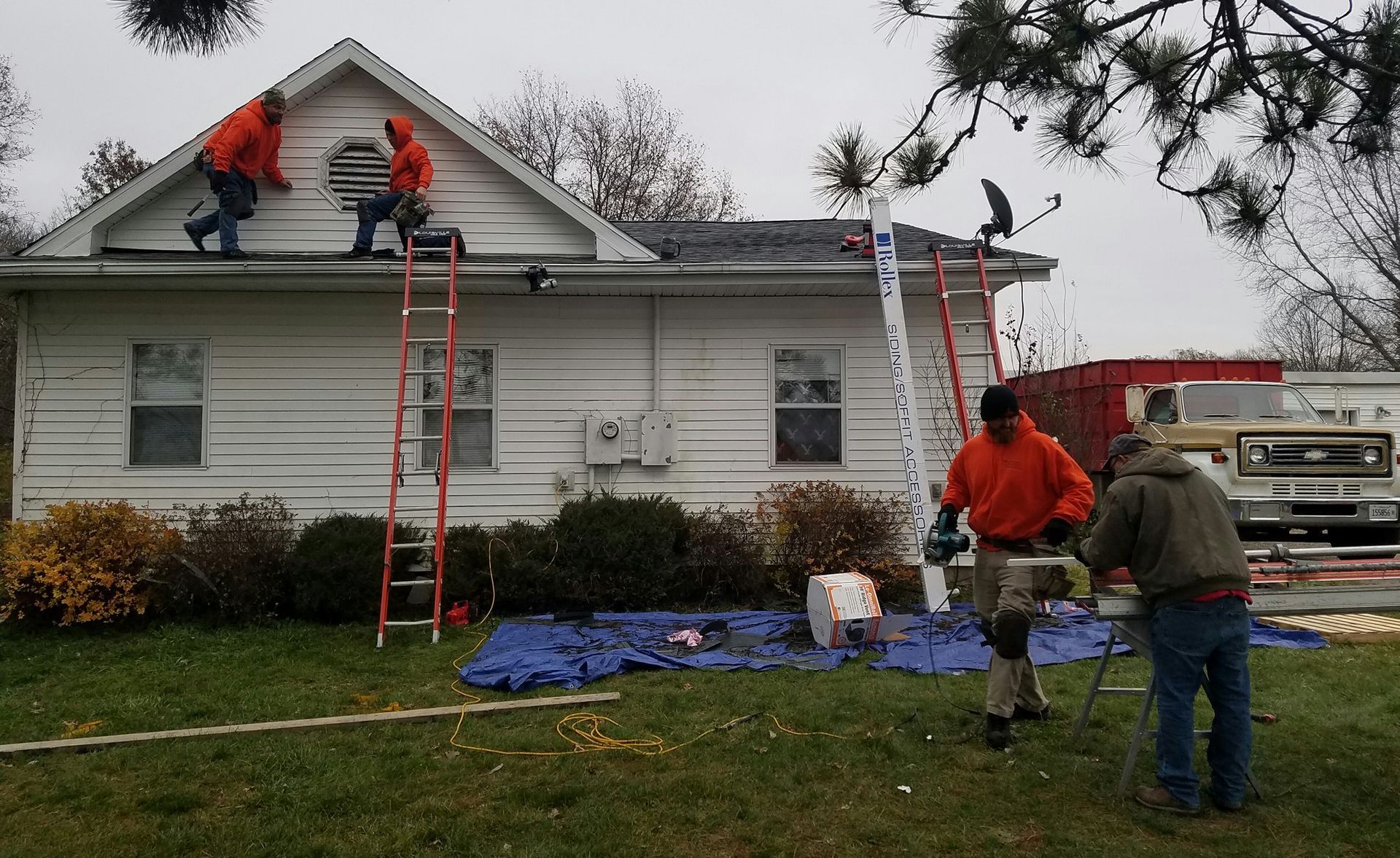 A group of men are working on the roof of a house