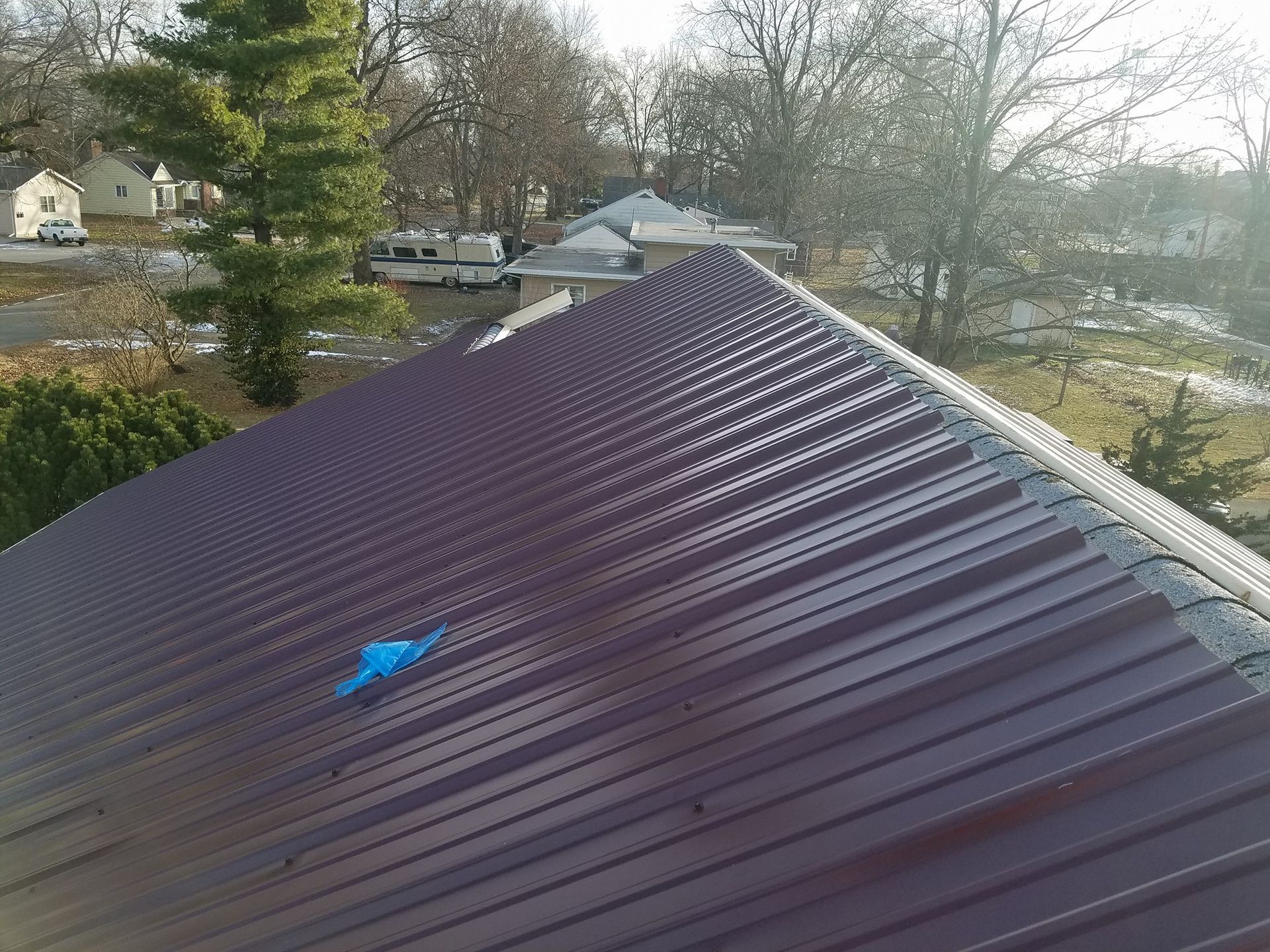 A close up of a roof with a blue tarp on it.