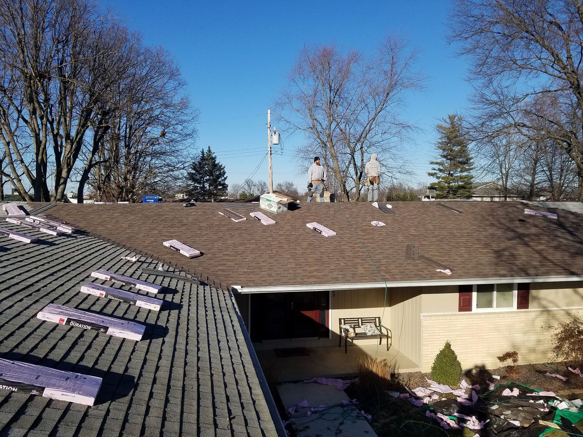 A group of men are working on the roof of a house.