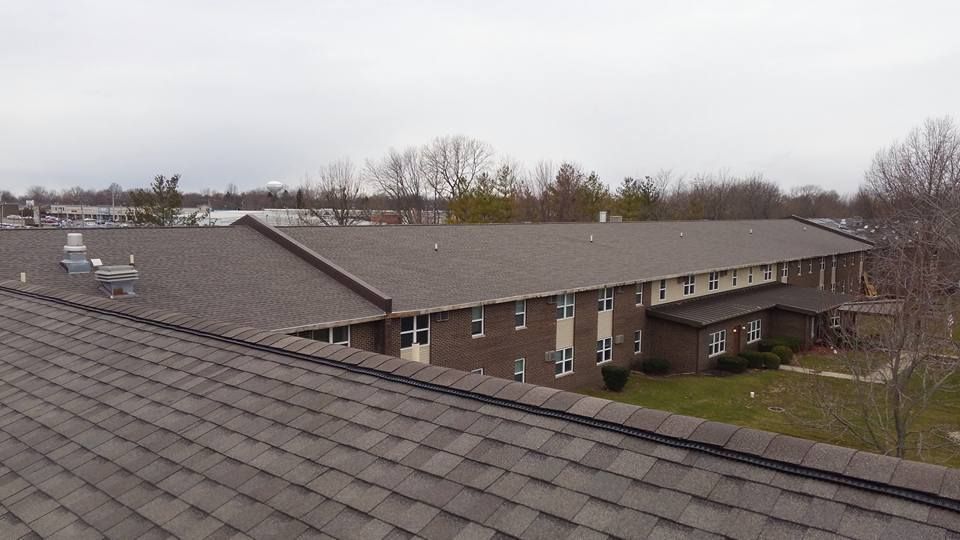 A large brick building with a roof that is covered in shingles.