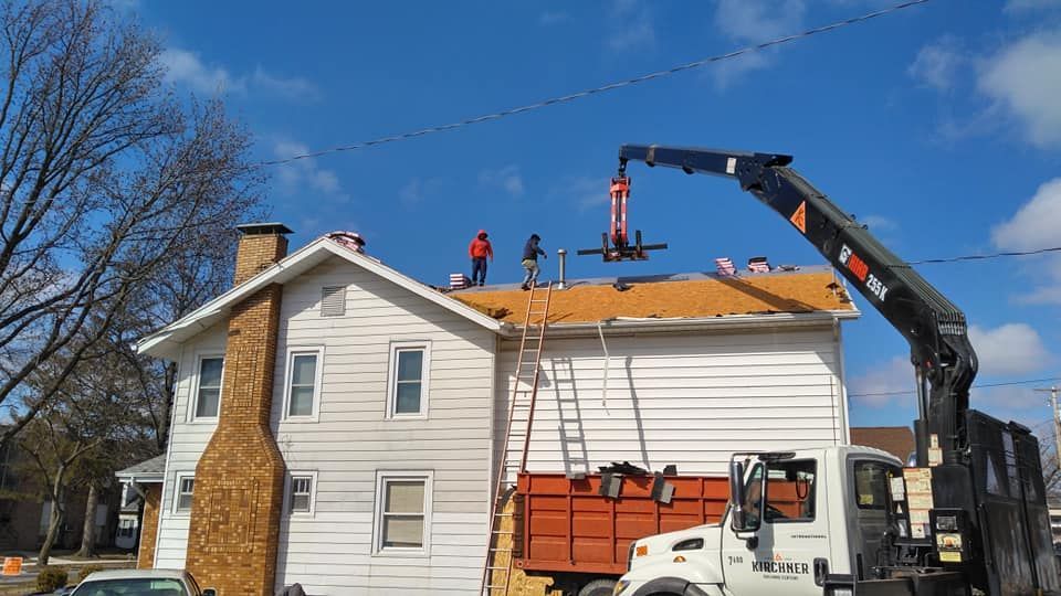 A crane is being used to install a roof on a house.