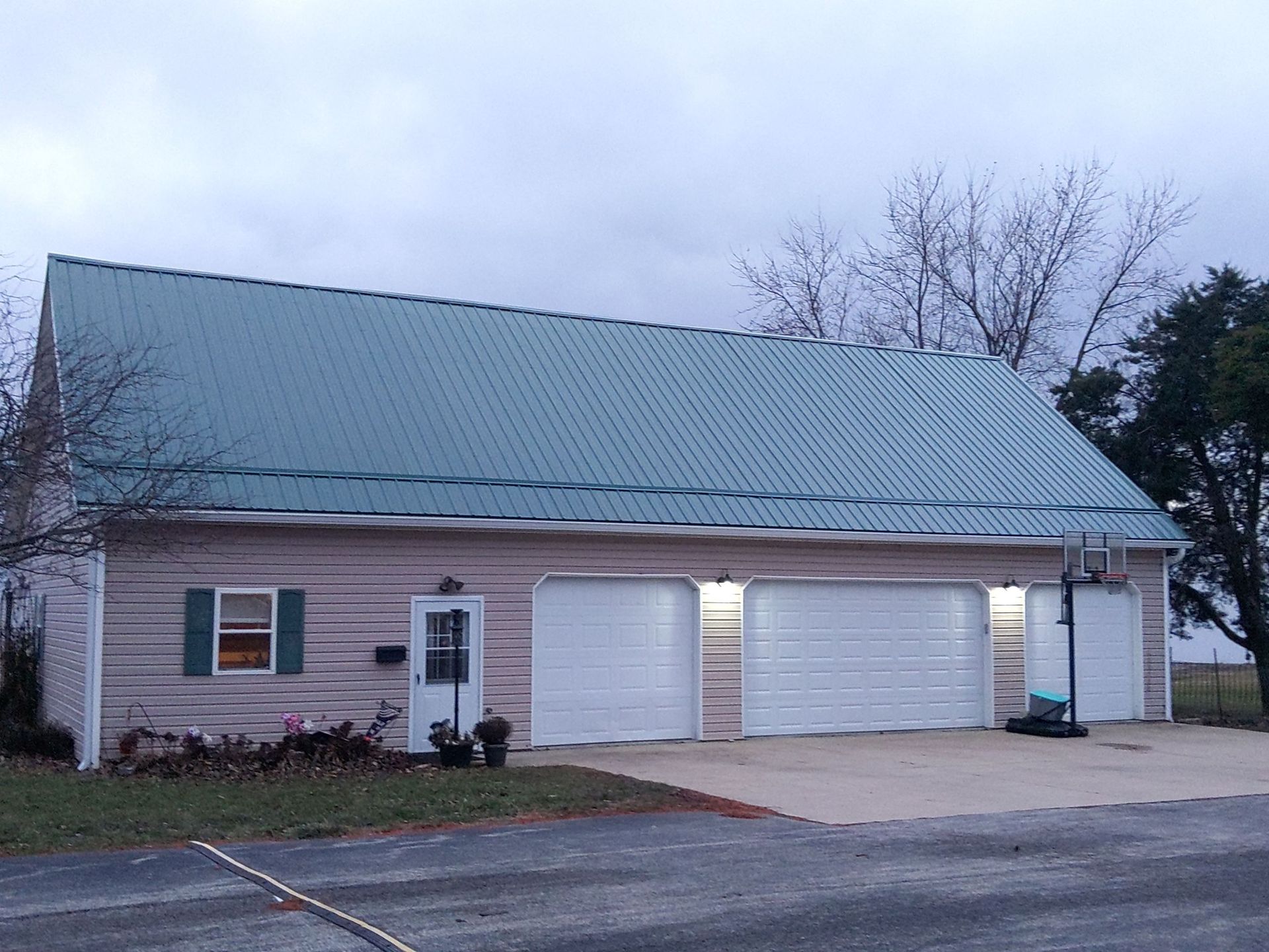A house with a green roof and white garage doors