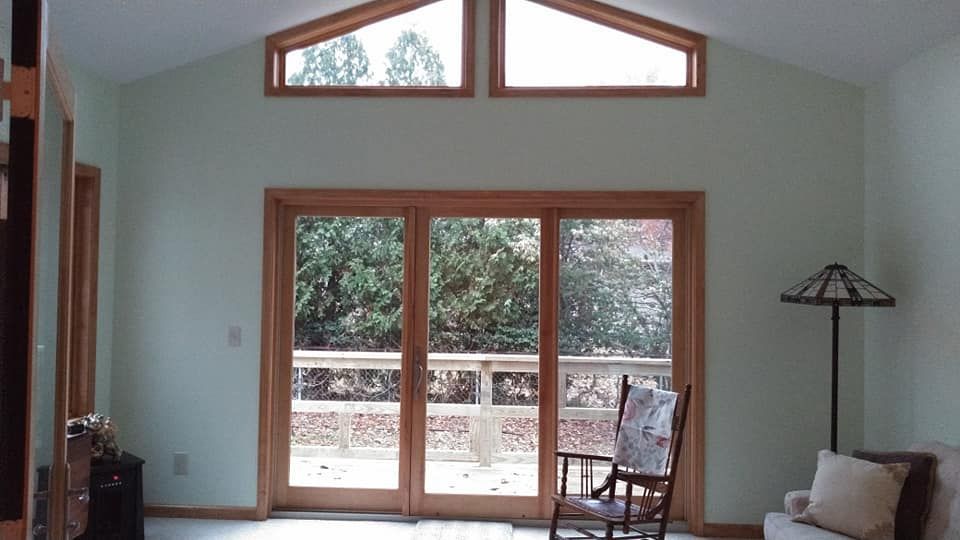 A living room with a rocking chair and sliding glass doors
