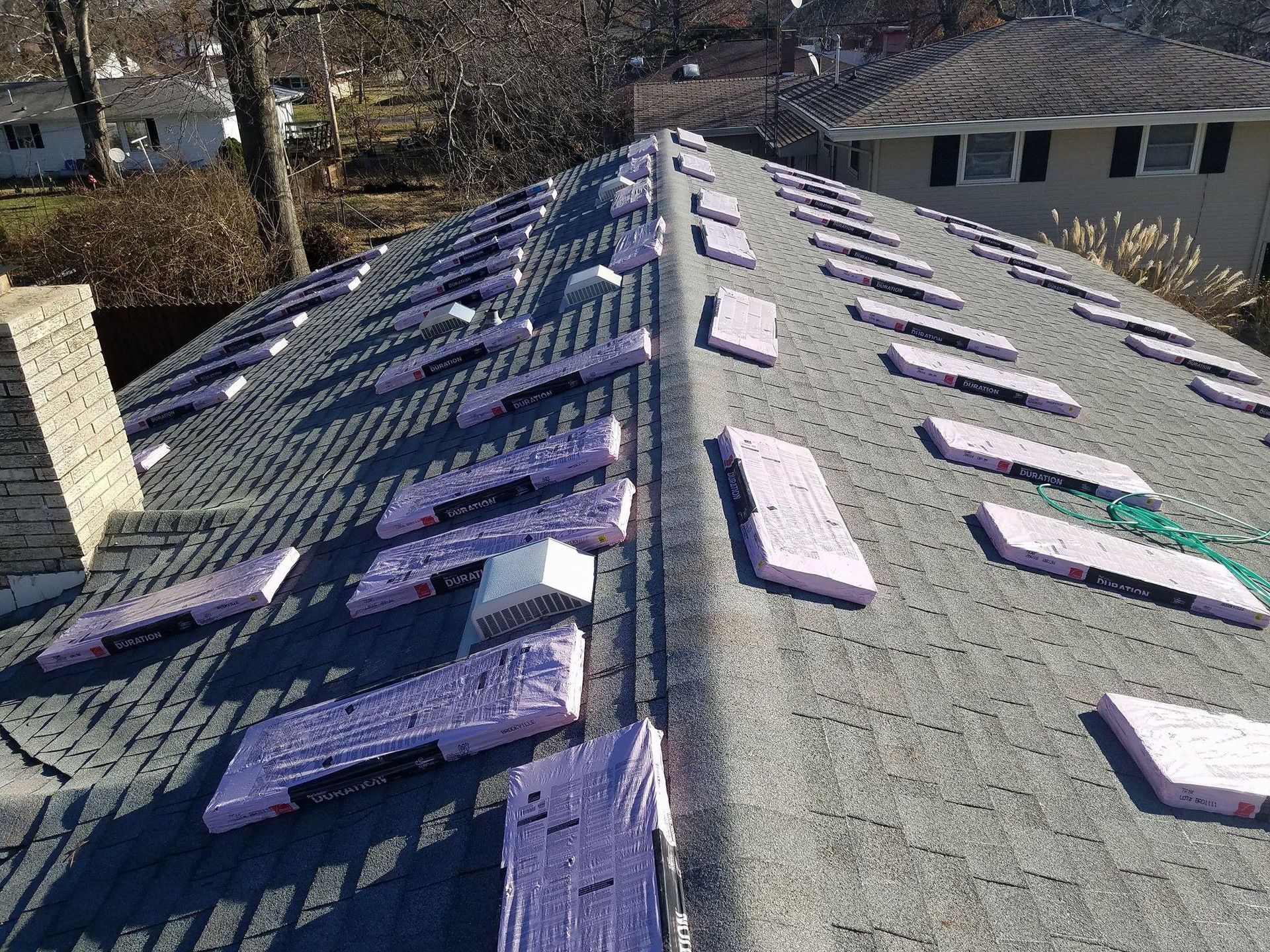 A roof with a chimney and a lot of shingles on it