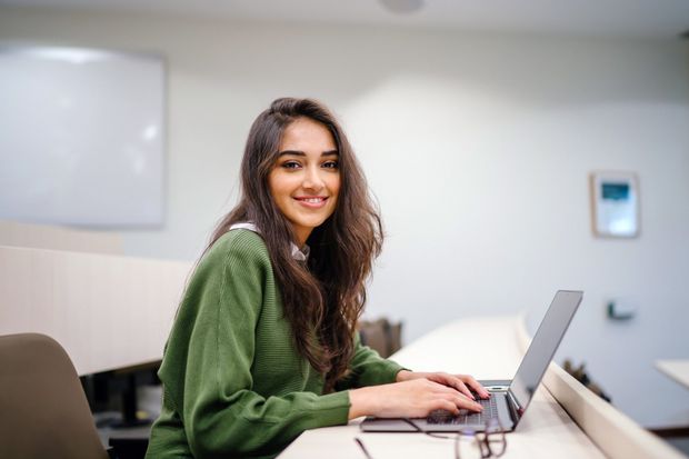 Focused businesswoman writing in notebook during work in office