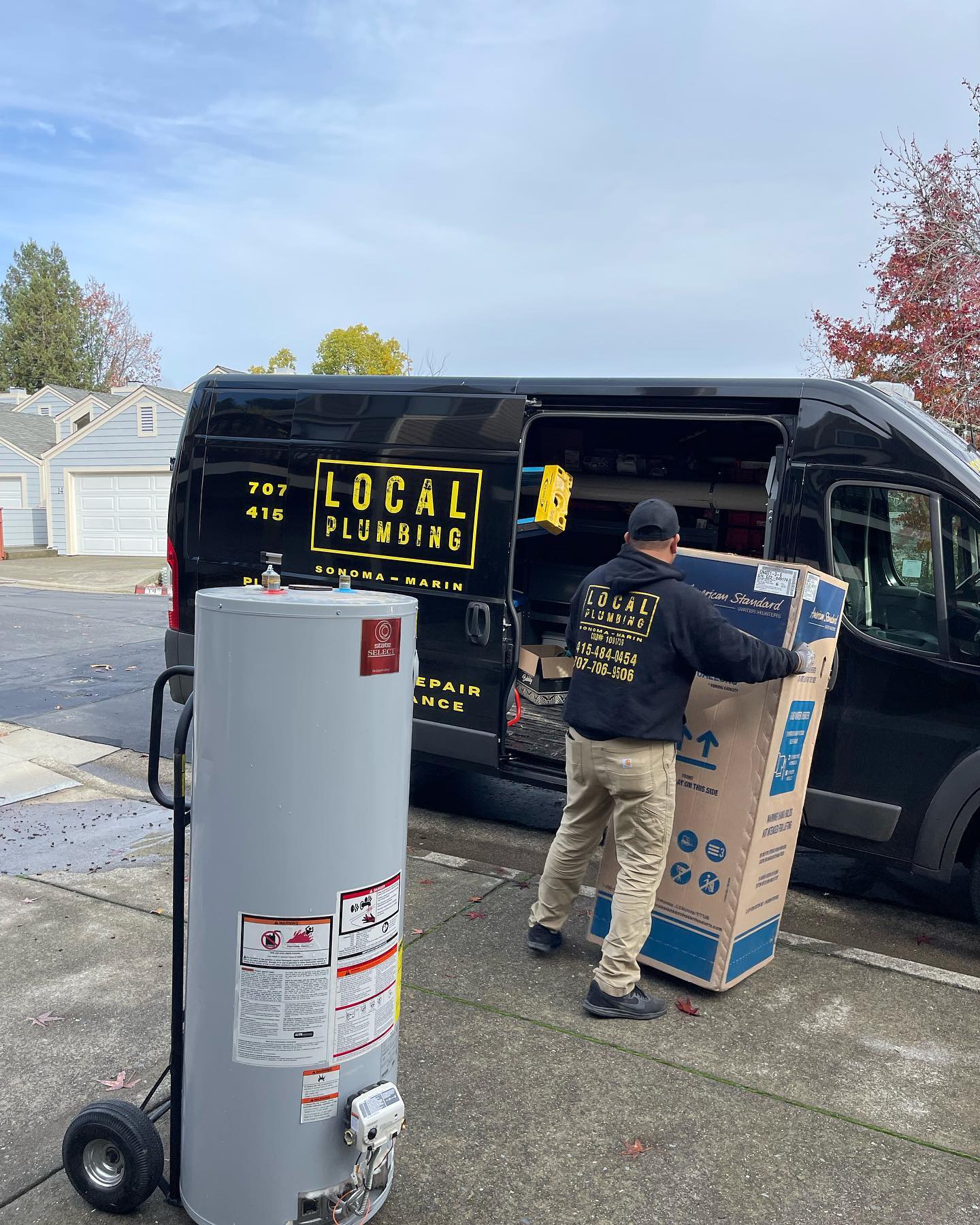 Plumber unloading a box from a black van with